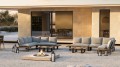 Zestaw wypoczynkowy Tierra Outdoor Seto Teak Lounge w aranżacji tarasowej, z narożnikiem z teaku, aluminiową ramą i stolikiem kawowym, ustawiony przy nowoczesnym domu.